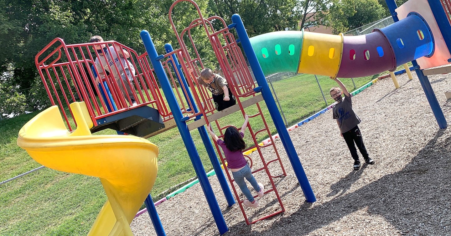 Children play on playground equipment