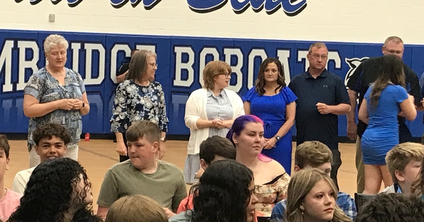 Teachers shake hands with grads